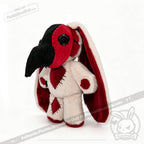 Plushie Dreadfuls plush doll with long red and white ears, black beak like a plague mask, and red heart patch.