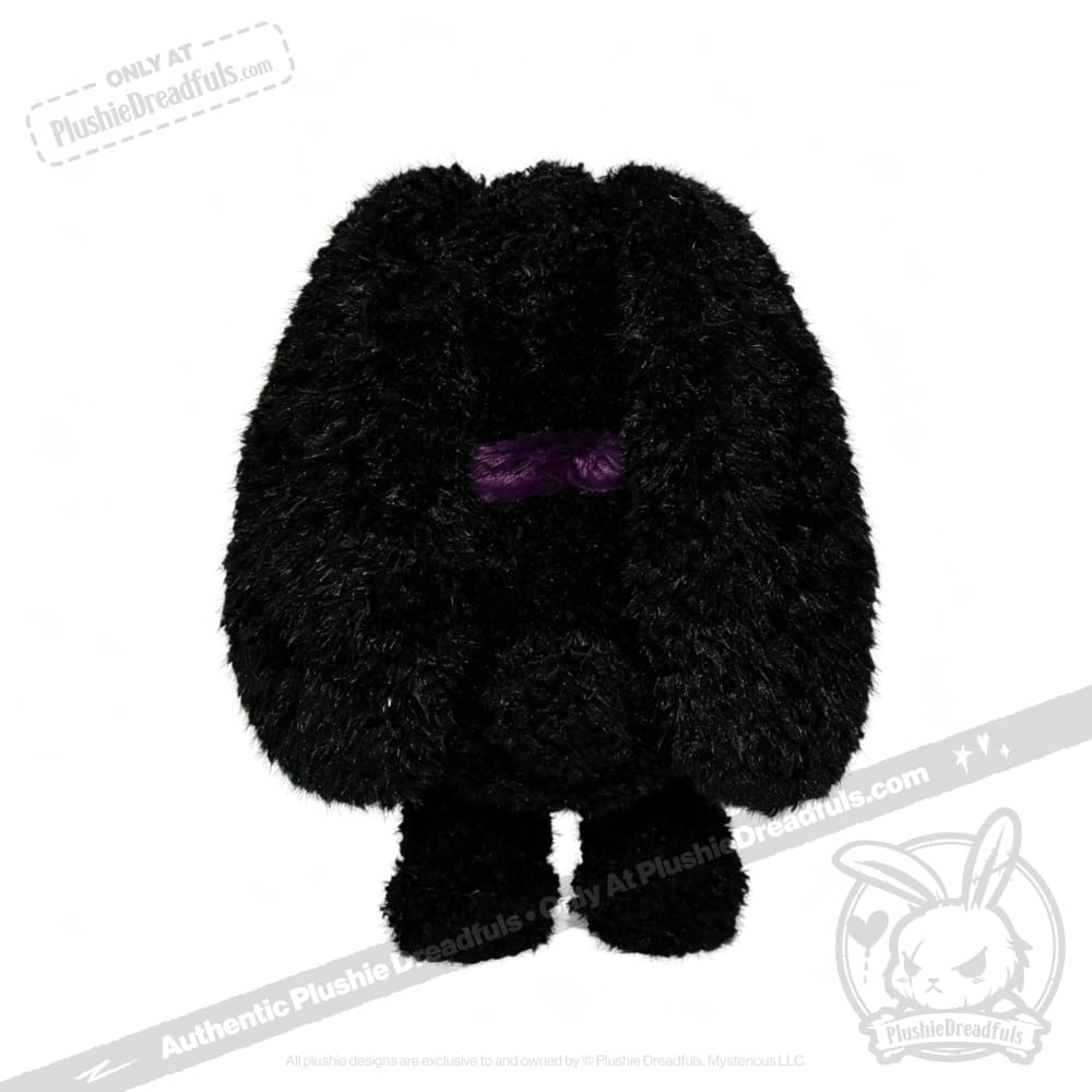 A fuzzy black Plushie Dreadfuls plush stuffed animal with floppy ears and a small purple line for eyes, standing upright.