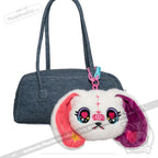 A denim handbag with a Harajuku Alice Rabbit plushie dreadfuls keychain attached by a blue and pink clip.