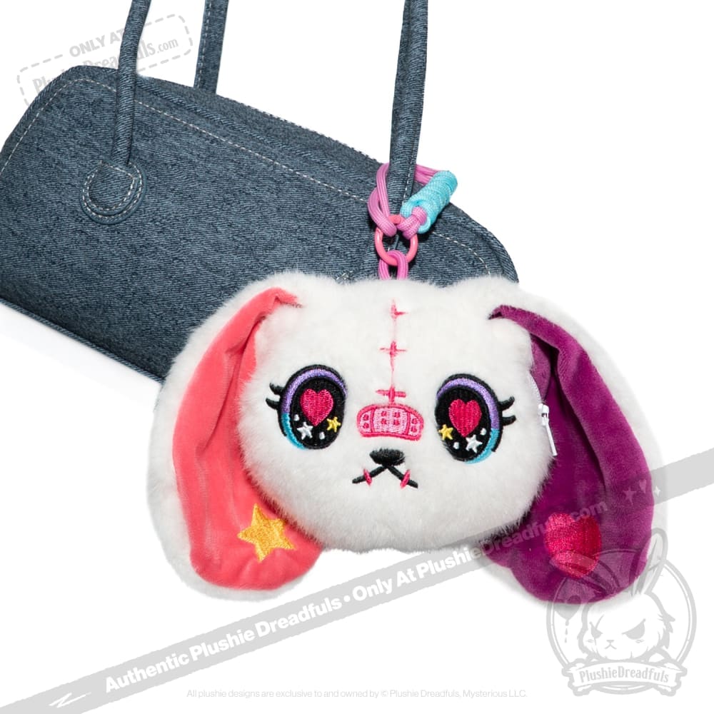 Plush bunny face keychain inspired by Harajuku Alice Rabbit, with colorful ears and heart eyes on a blue handbag.