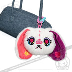 Plush bunny face keychain inspired by Harajuku Alice Rabbit, with colorful ears and heart eyes on a blue handbag.