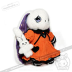 White plush bunny in an orange dress with a heart, inspired by the Victorian Anxiety Rabbit, holds a smaller bunny plush.