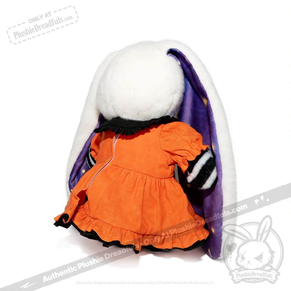Plush toy with long white ears, an orange dress with black trim—Wonderland plush toy shown from the back against white.