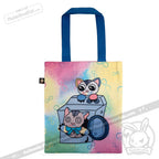 Colorful tote bag with blue handles, featuring cartoon cats—one peeking from a washing machine and another sitting on top. The pastel yellow, pink, and blue background with infinity symbols is inspired by the whimsical style of the Victorian McGee's Autism Acceptance Cheshire Cat - Plush Stuffed Animal to celebrate autism acceptance.