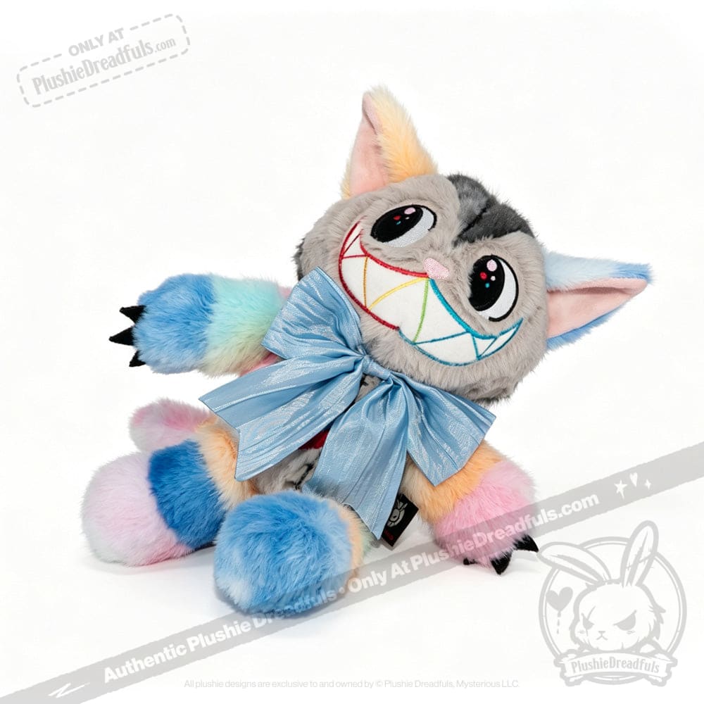 A plush Victorian McGee's Autism Acceptance Cheshire Cat stuffed animal, featuring rainbow-colored fur, a big embroidered rainbow smile, wide eyes, and a large light blue bow around its neck, sits against a white background—an enchanting collectible inspired by Alice in Wonderland and perfect for celebrating autism acceptance.