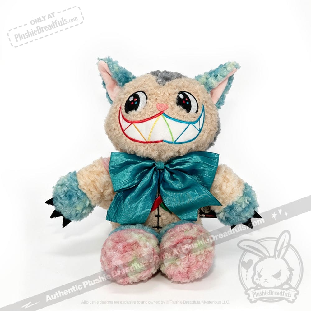 A whimsical, multicolored plush inspired by Alice in Wonderland, the Victorian McGee's Autism Acceptance Cheshire Cat - Plush Stuffed Animal features big eyes, a wide rainbow-stitched grin, pastel-hued pointy ears and paws with black claws. Accented with a large teal bow, it sits charmingly against a white background—a playful tribute to autism acceptance.
