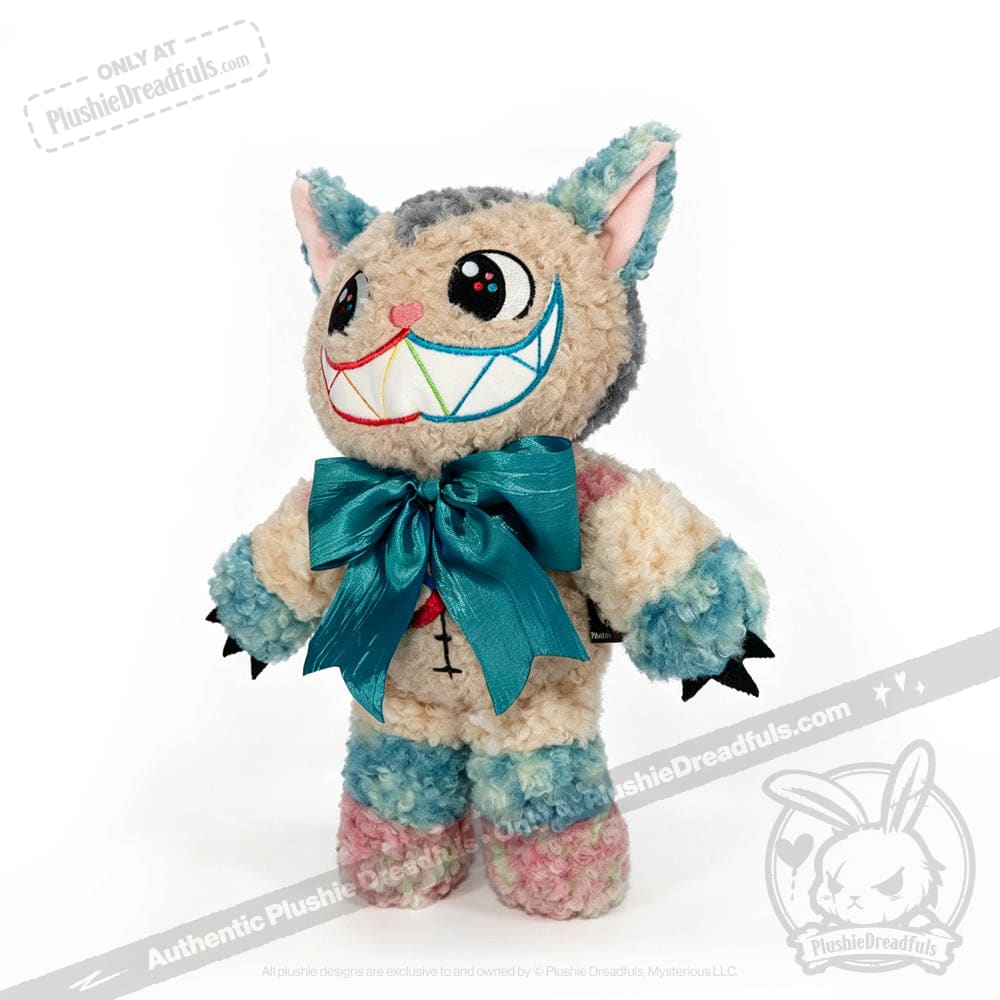 Victorian McGee's Autism Acceptance Cheshire Cat - Plush Stuffed Animal features a wide, toothy grin, colorful pastel fur, large blue bow, pointy ears, and black claws. Inspired by the Alice in Wonderland plush collection, this plush cat showcases embroidered facial features and stands upright on a white background—serving as a whimsical symbol of autism acceptance.