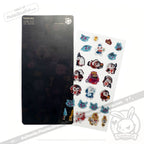 A sheet of colorful cartoon character stickers displayed next to a black backing board on a plain white background. The stickers feature various paws, cats, and fantasy characters in red, blue, white, and gold.