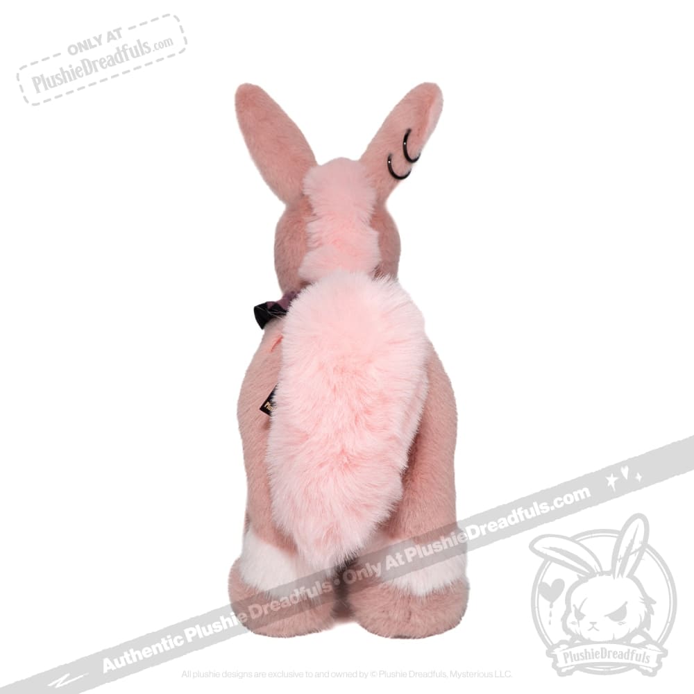 A pink limited edition plushie bunny sits facing away, showing its fluffy tail and upright ears.
